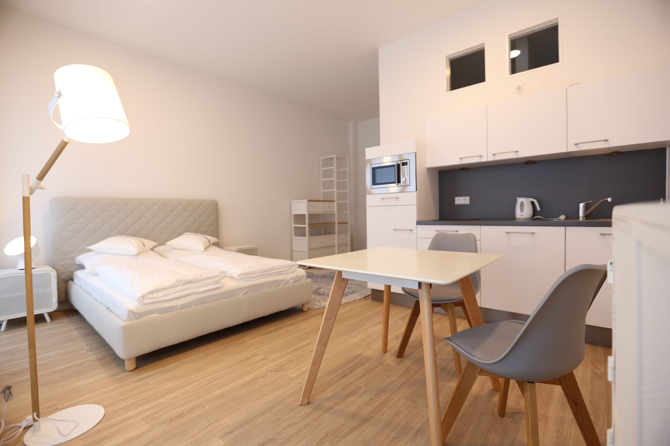 Helles Apartment mit Bett, Schreibtisch und integrierter Küchenzeile, moderner Stil