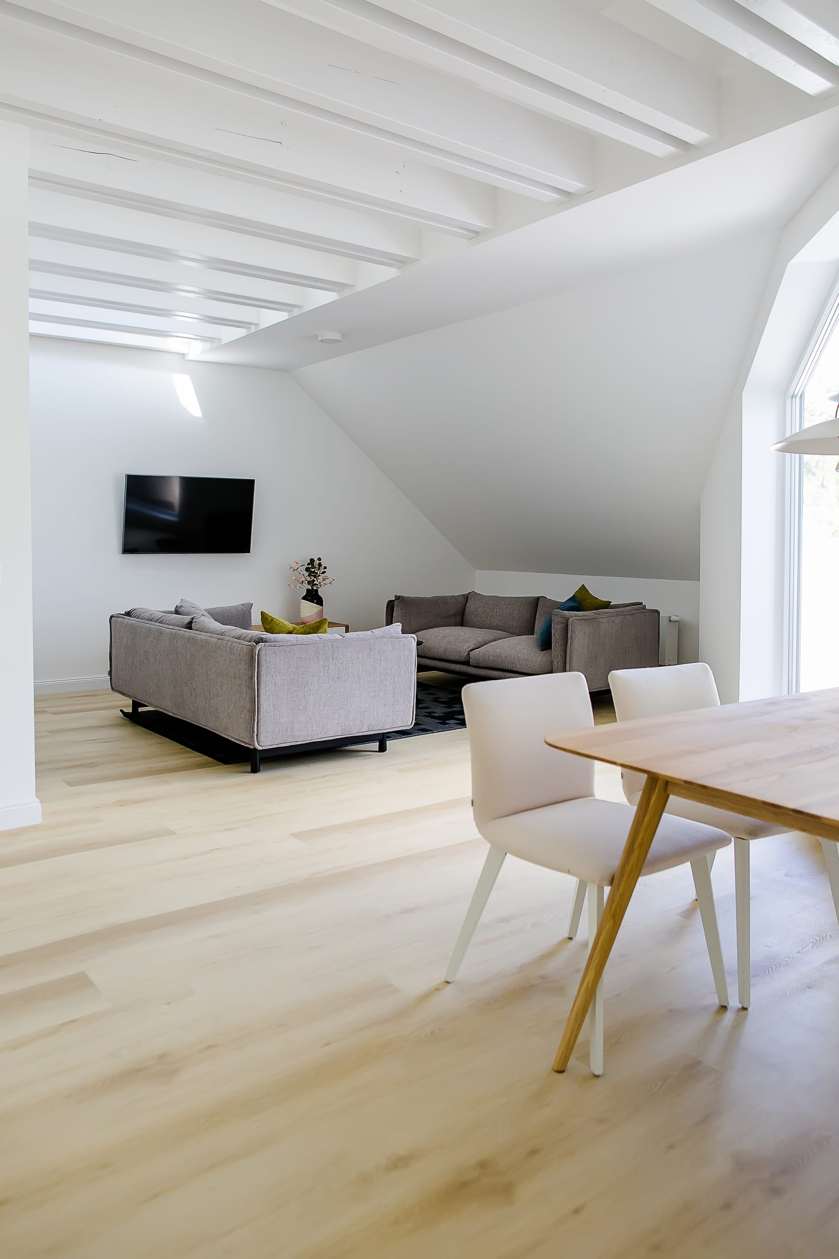 Heller Wohn- und Essbereich mit Holzboden, beigem Sofa und Couchtisch, Esstisch mit Stühlen