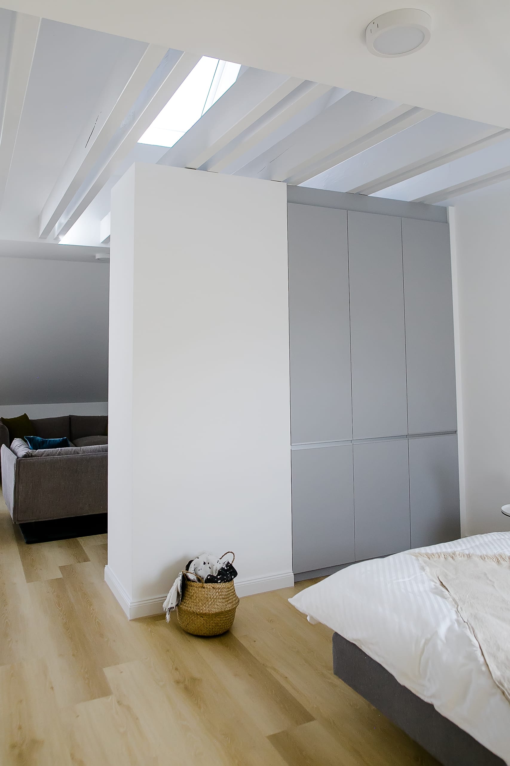 Doppelzimmer mit Bett, Holzfußboden und Einbauschrank, Decke mit Lichtstreifen